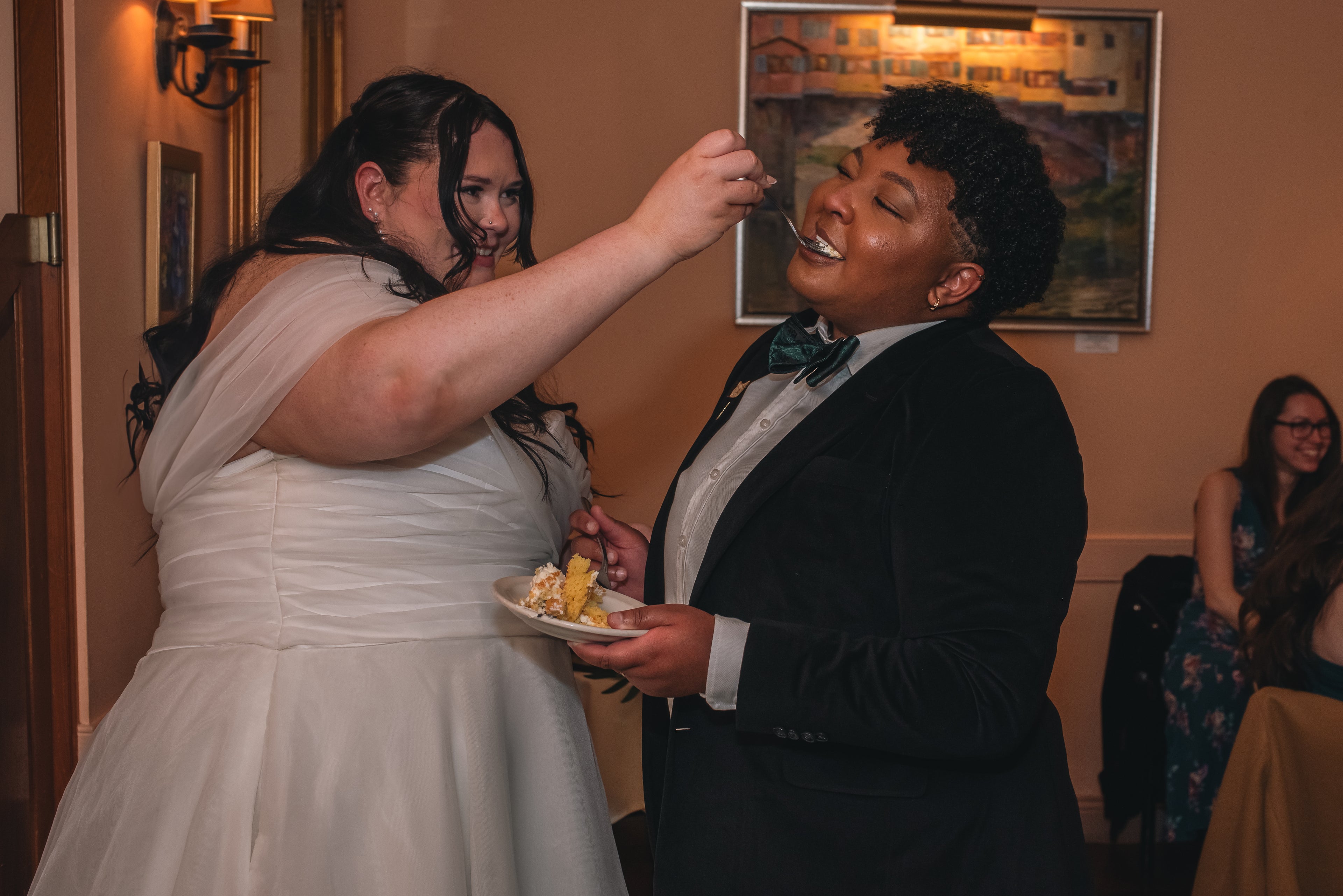 Newlyweds feeding each other cake.