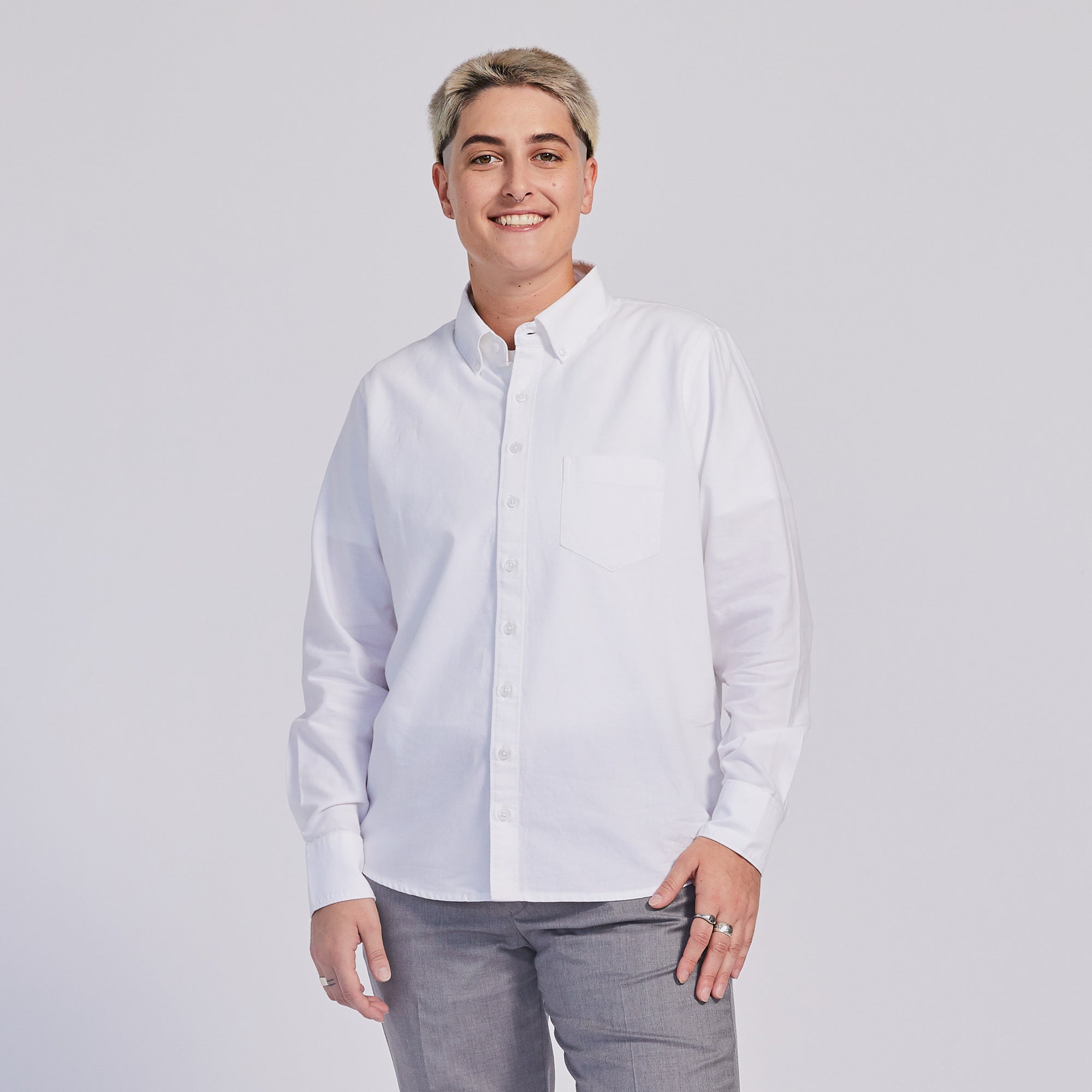 Masc model in white Oxford button down shirt. Color: White