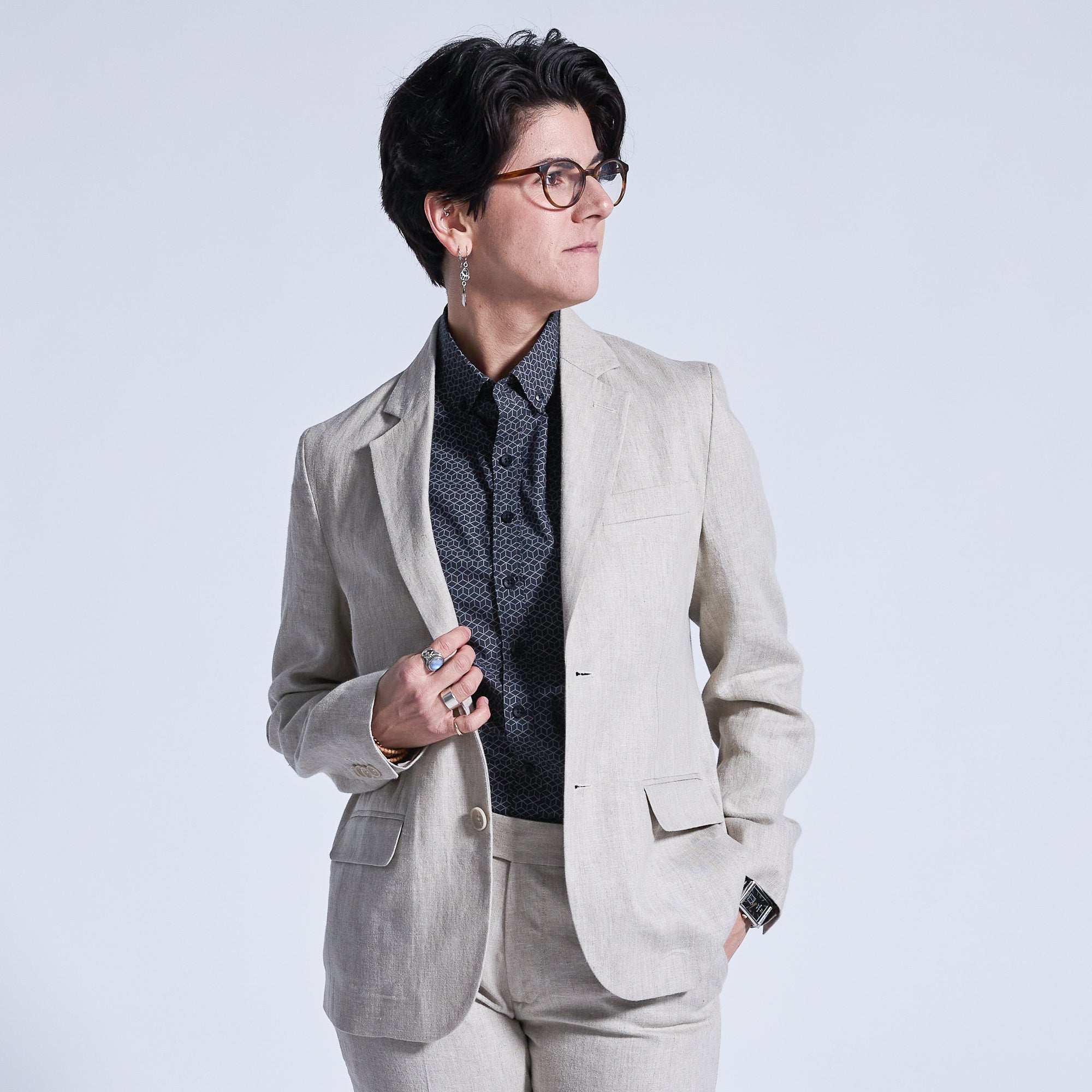 Model wearing Oat linen blazer and dress pants looking to the right.  Color: Oat