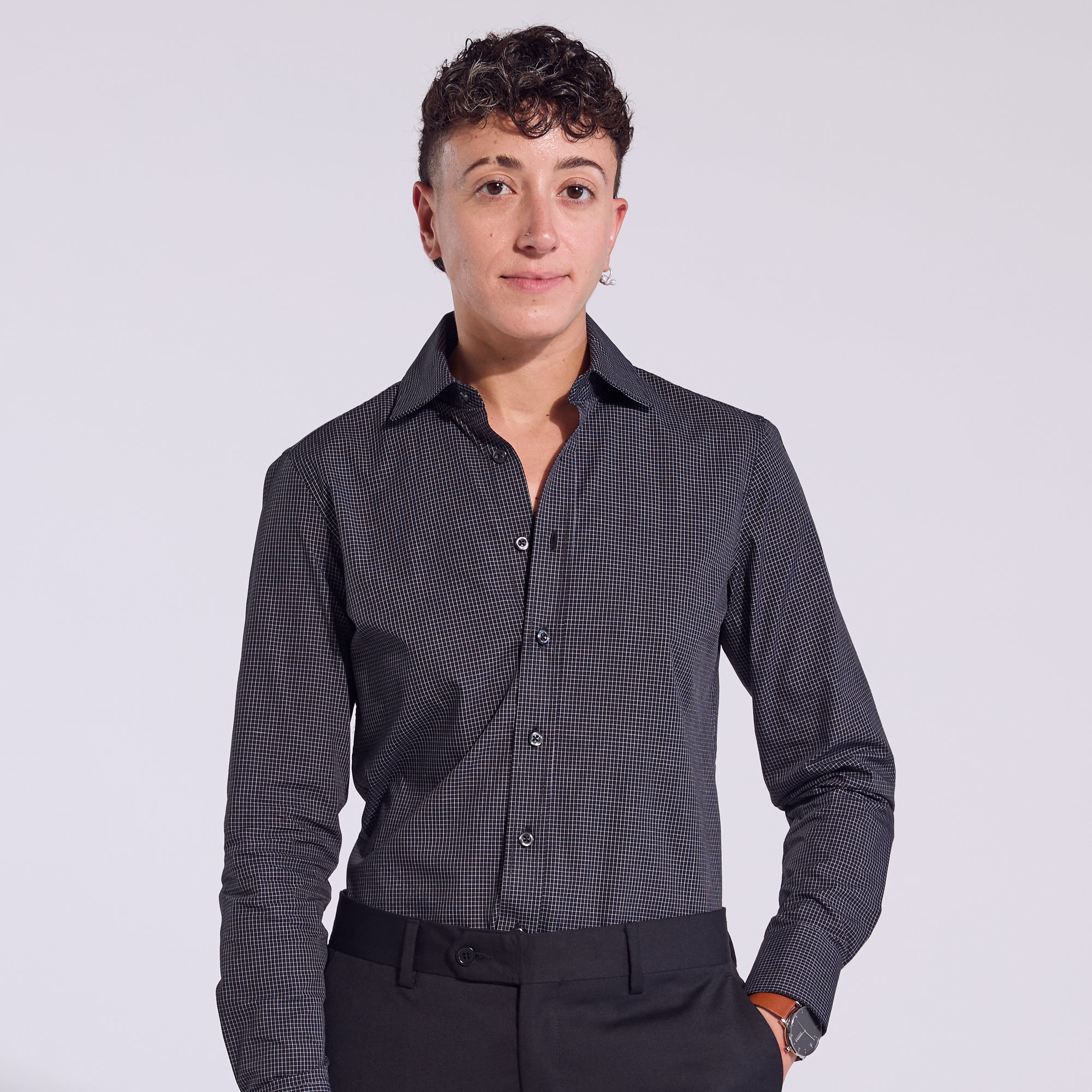 A person modeling a long-sleeve black mini grid dress shirt with a spread collar. Color: Black Mini Grid
