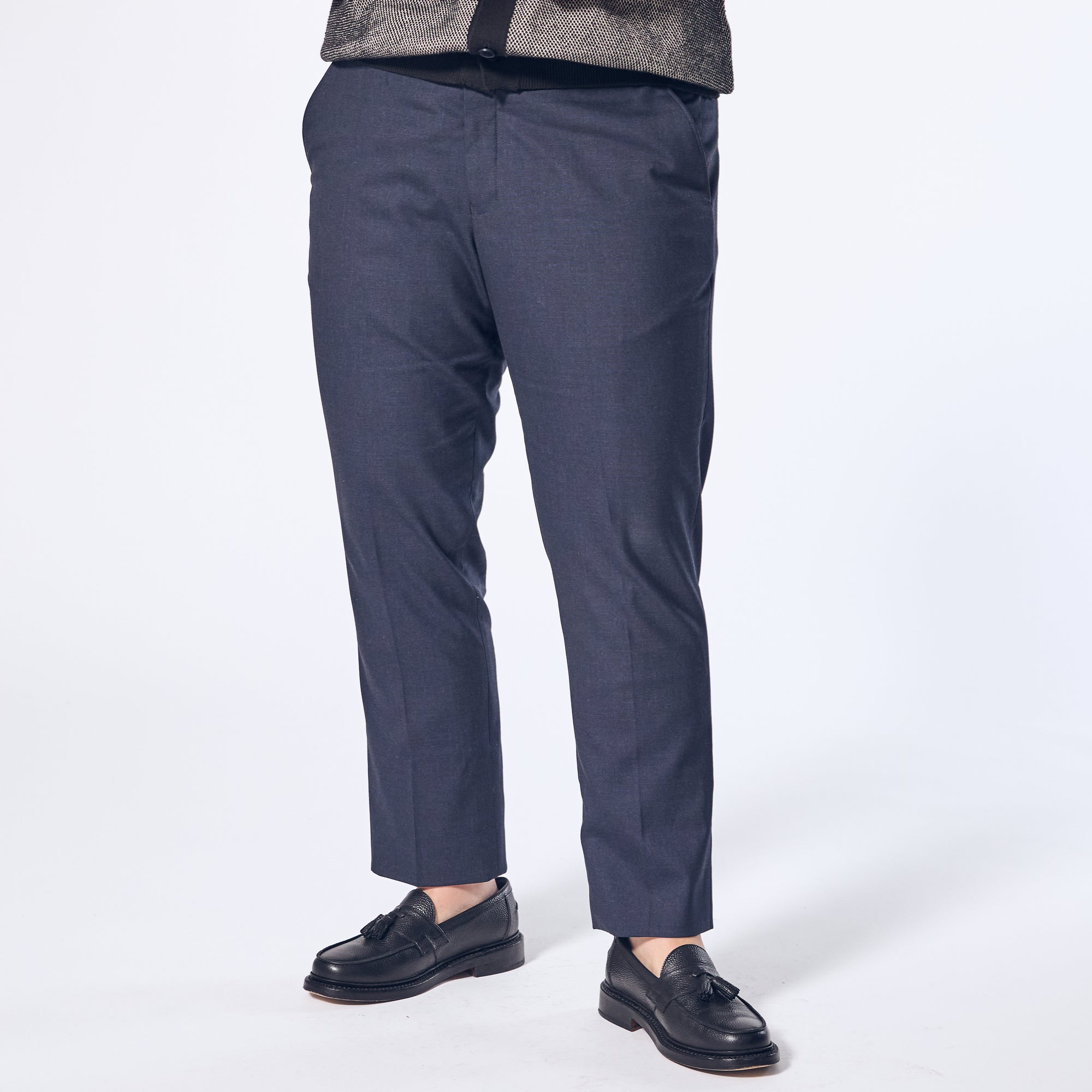 Model wearing The Scout Ink Blue Dress Pants made by Kirrin Finch on a white background. Color:  Ink Blue