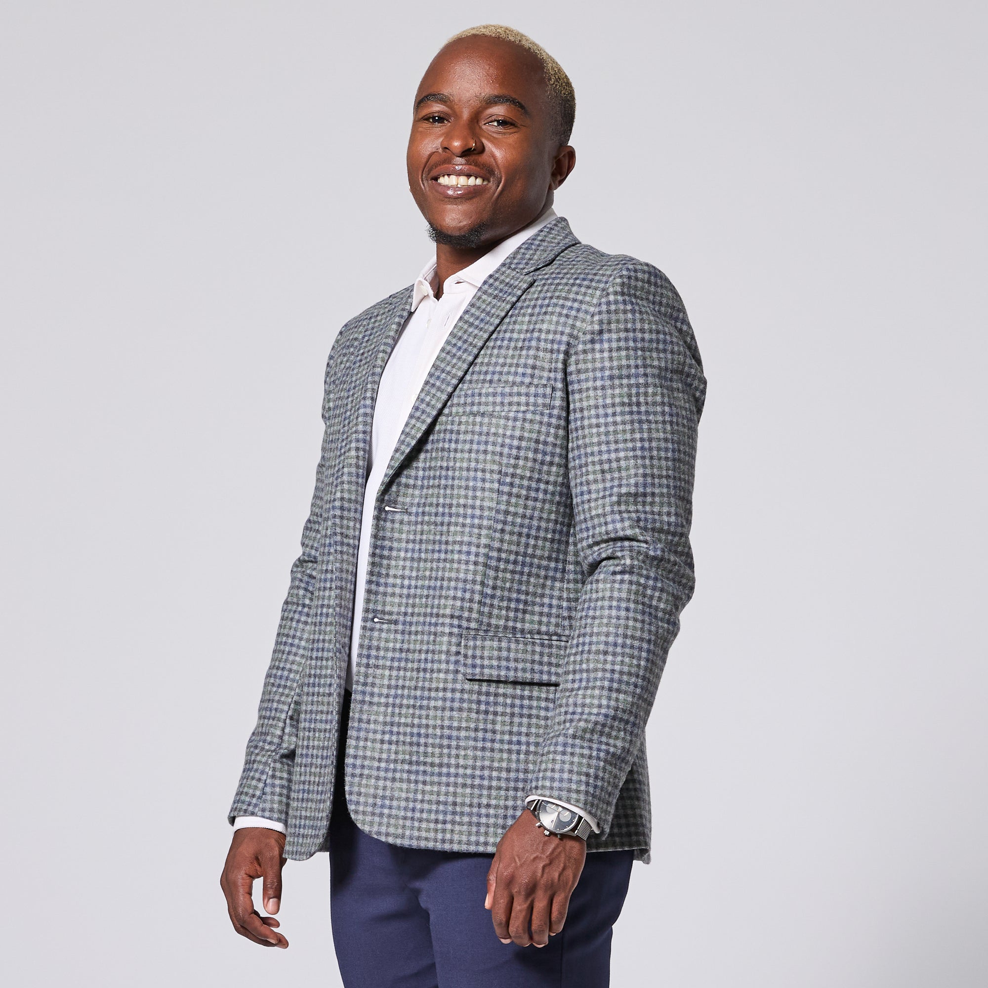Androgynous Model wearing the Finch Hunter Check blazer on a light gray background.  Color: Hunter Check