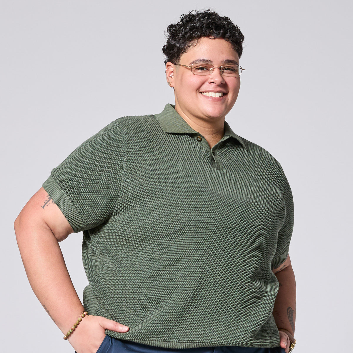 Androgynous model wearing The Hedge Green Pique Polo by Kirrin Finch. Color: Hedge Green