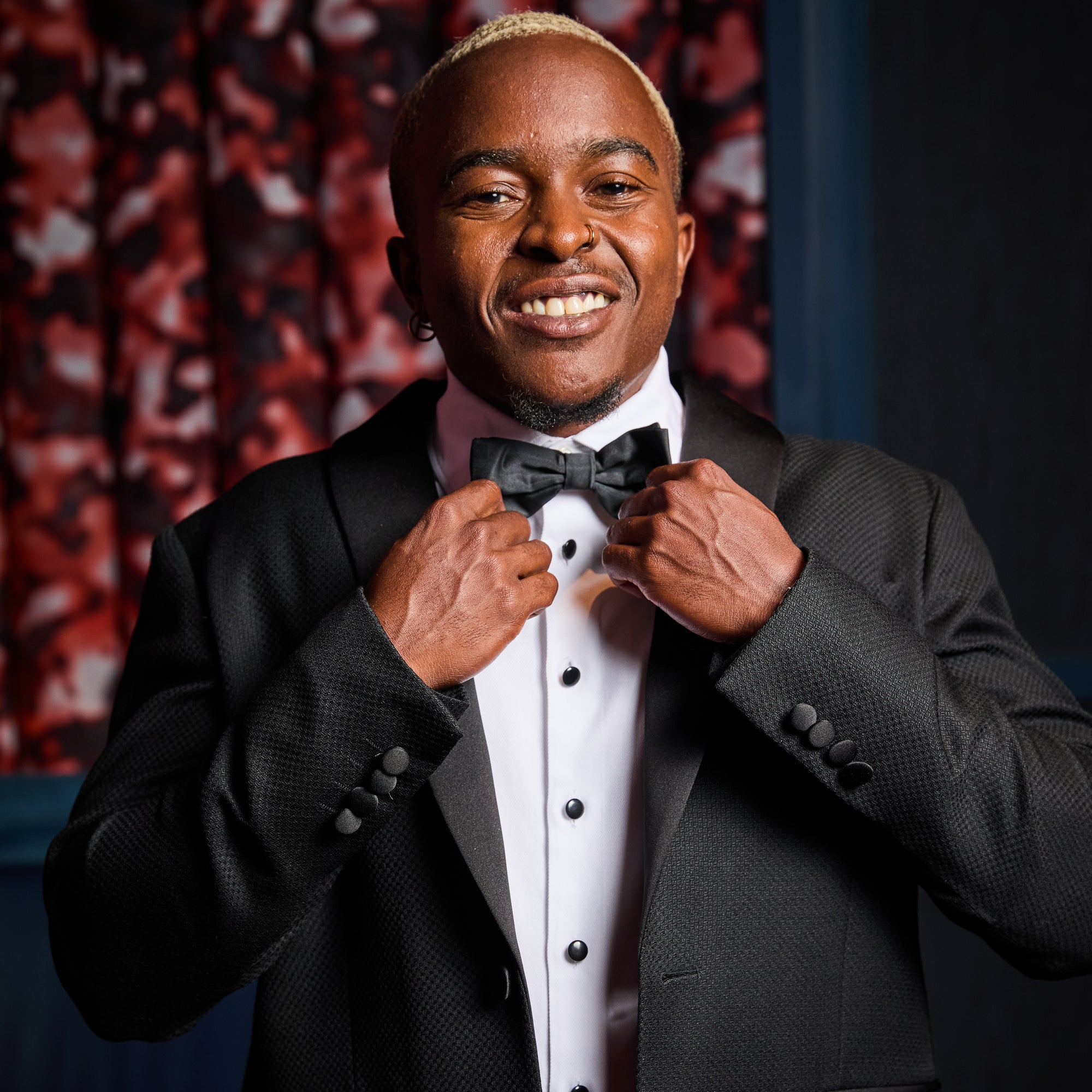 Masc model adjusting Kirrin Finch Bowtie on his Kirrin Finch Txuedo Shirt and Blazer.  Color: Textured Riviera