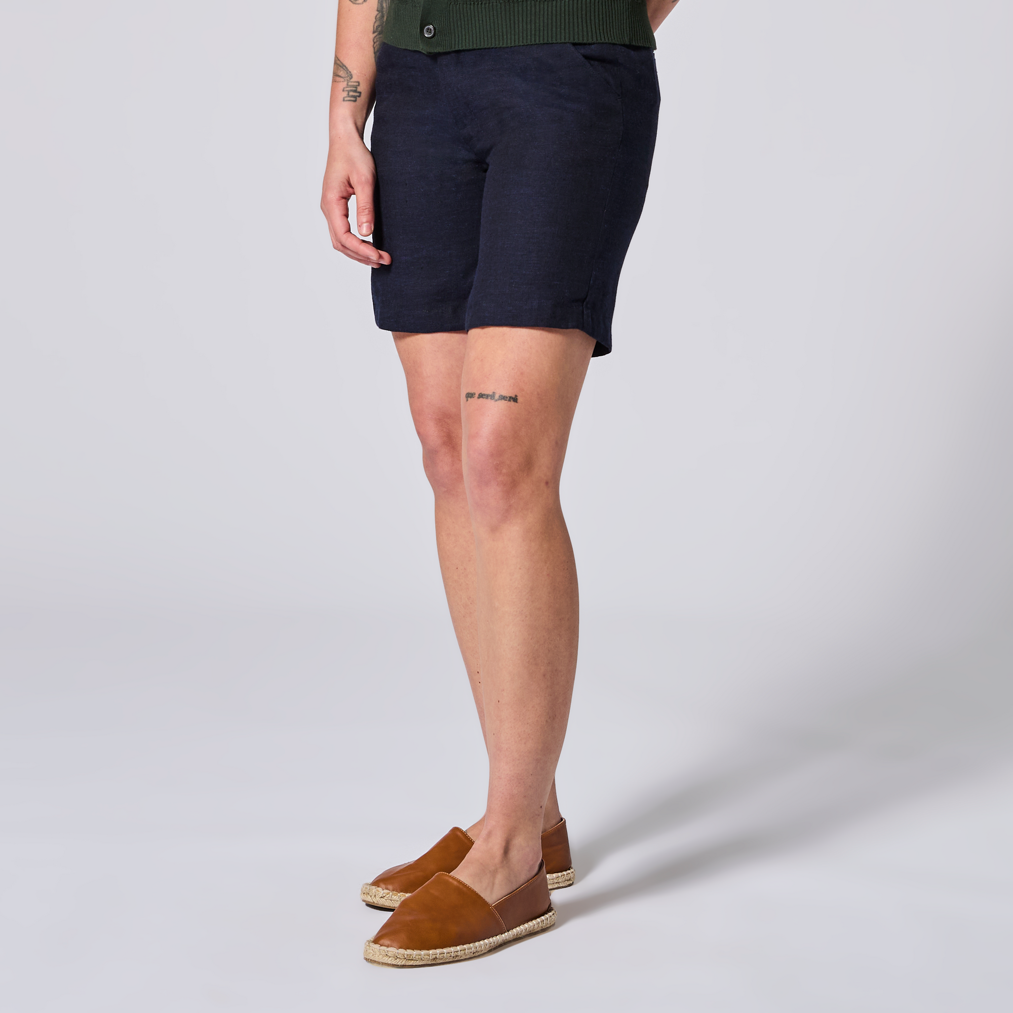 Person wearing navy shorts and brown shoes on a light gray background. Color: Marine Navy