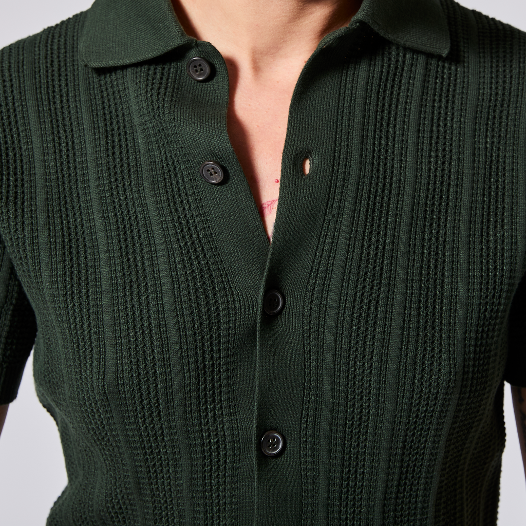 Green knitted cardigan with button details on a plain background. Color: Evergreen