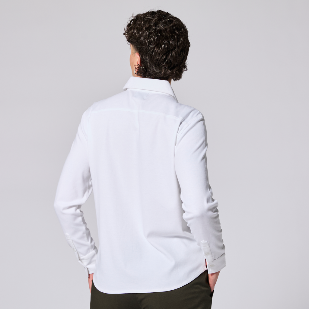 Model wearing a white dress shirt with long sleeves on a gray background. Color: White