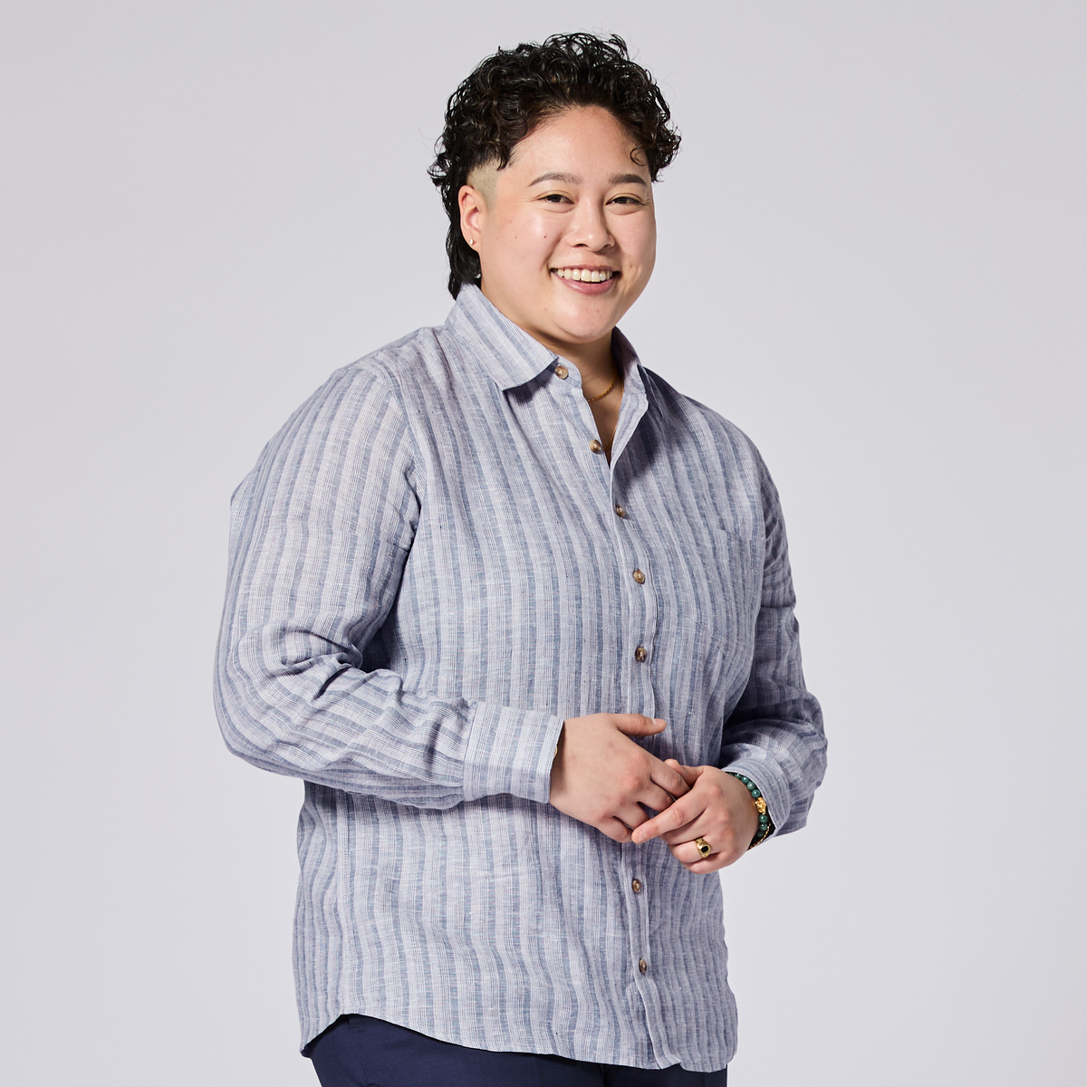 Person wearing a light blue striped shirt against a plain background. Color: Coastal Blue