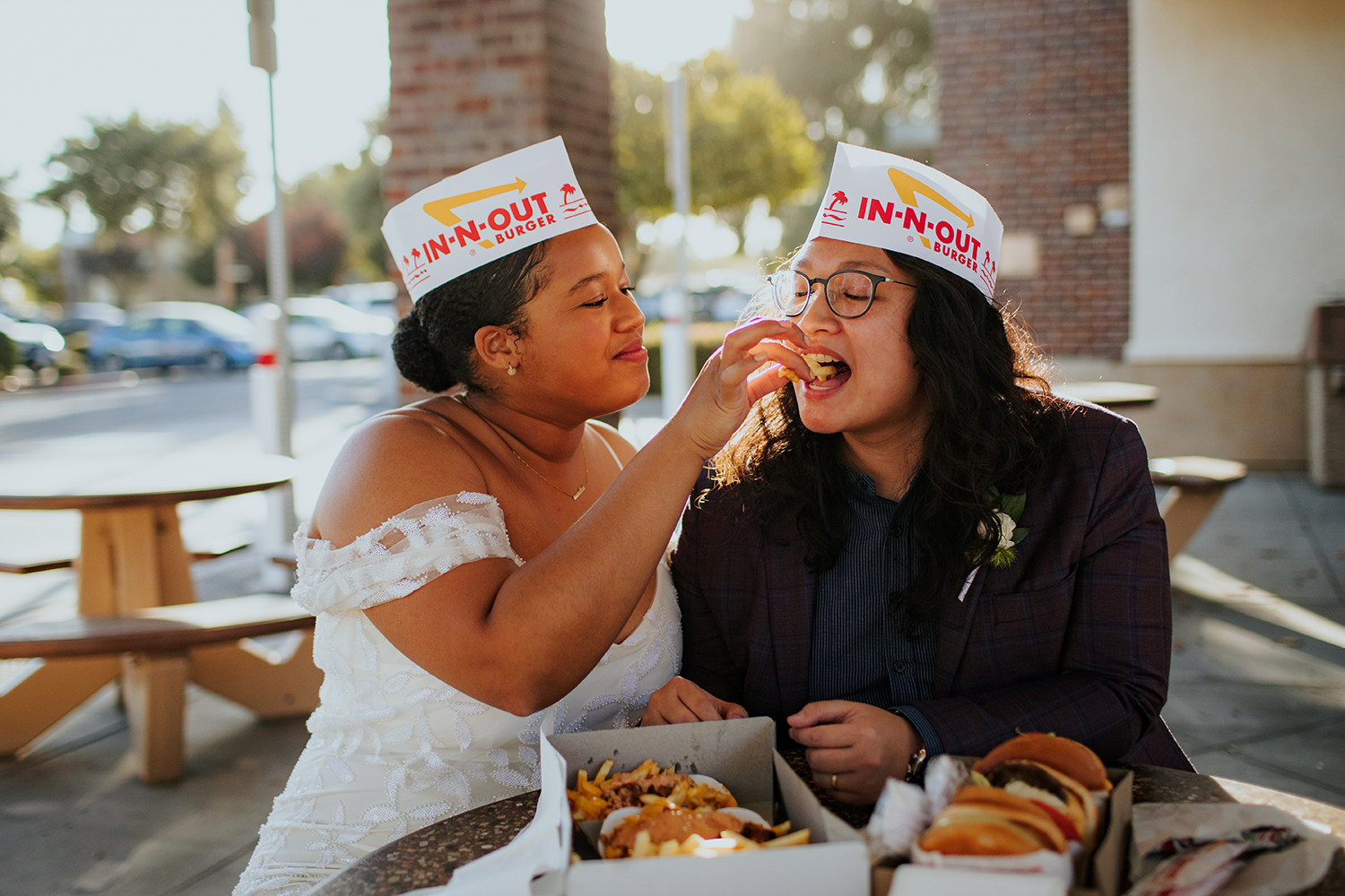 Andrea and Aidali wearing in-n-out burger hats in their wedding attire.