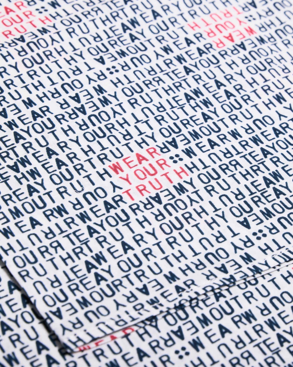 Text pattern with 'WEAR YOUR TRUTH' in red on a white bandana.