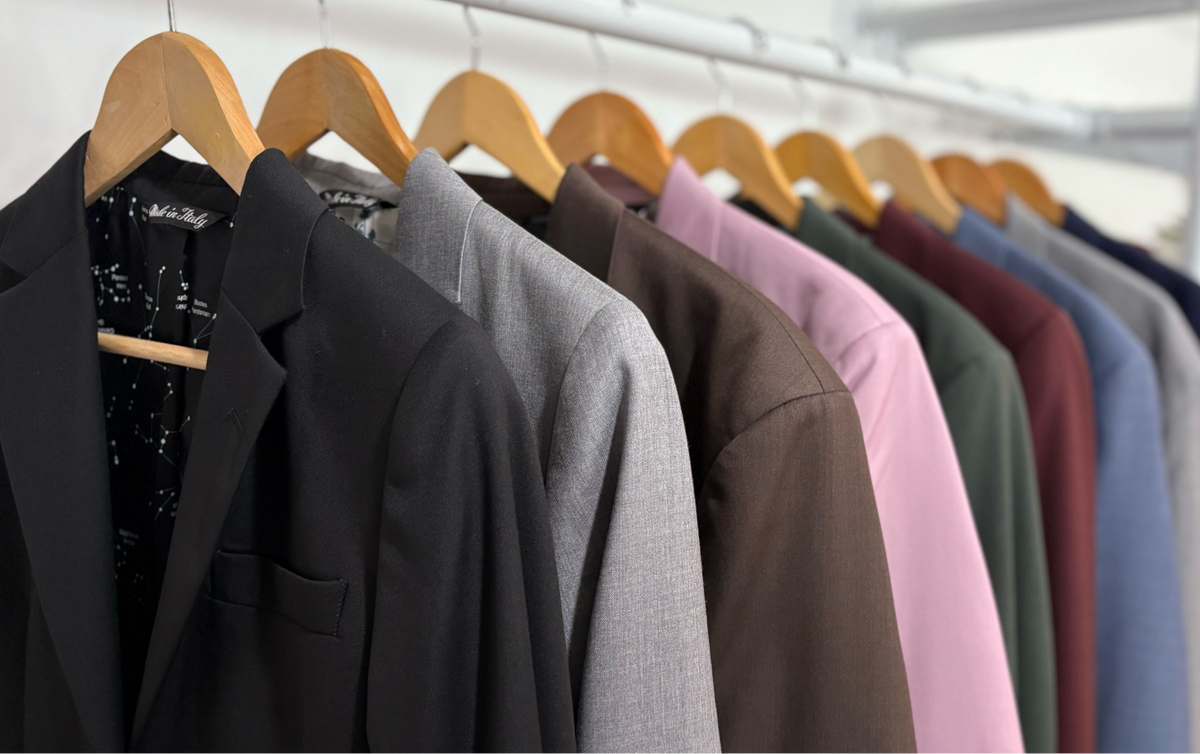 Row of jackets on wooden hangers against a white background