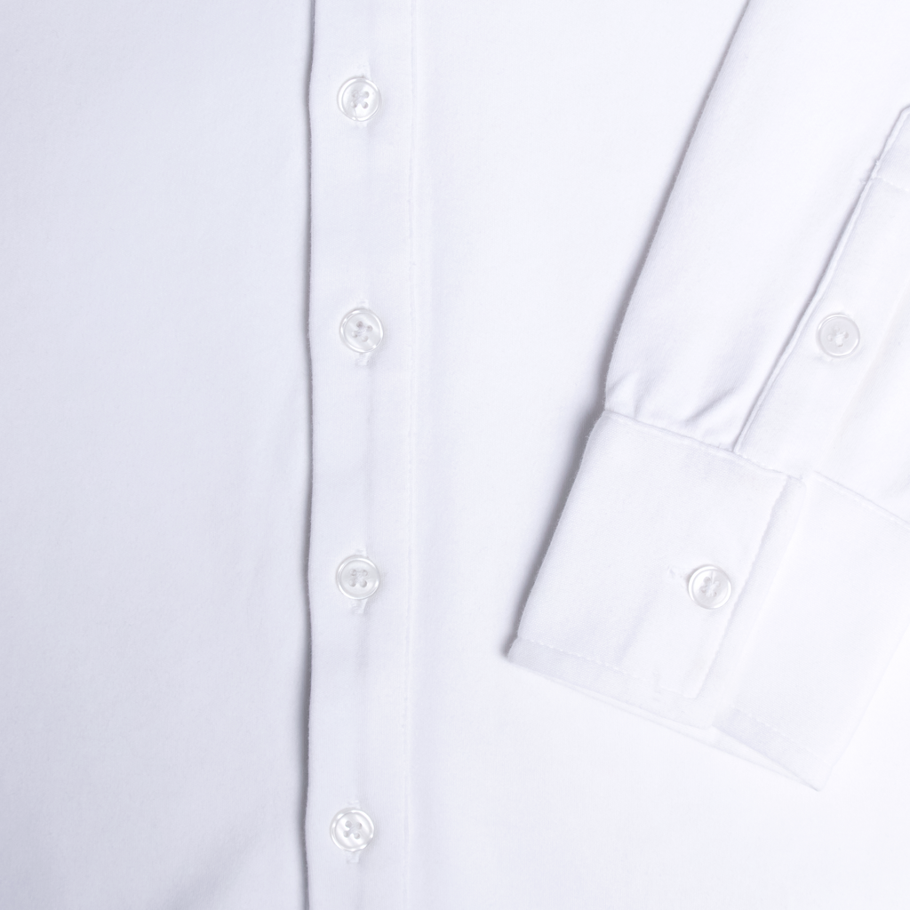 Close-up of a white shirt with button details. Color: White