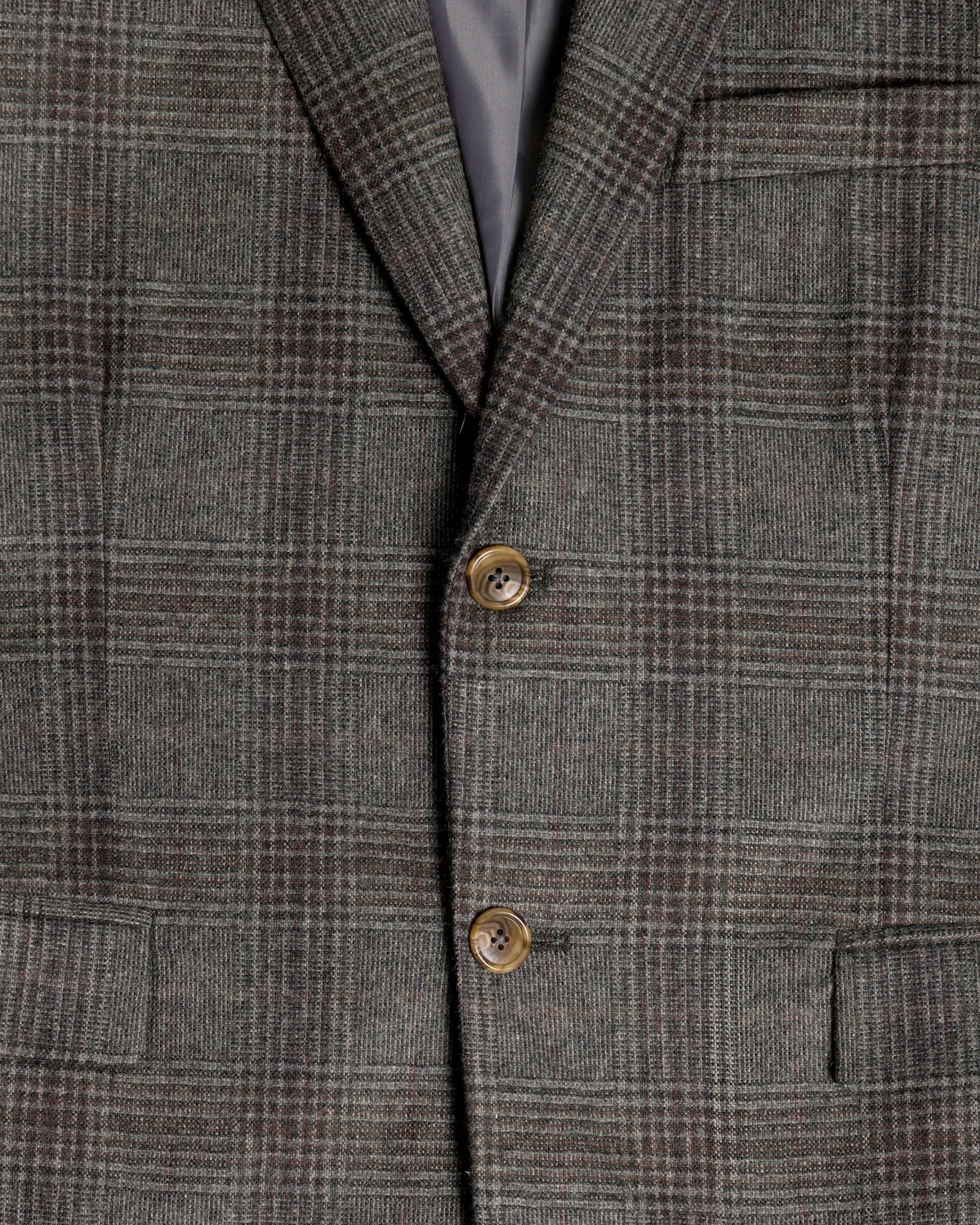Close-up of a gray and brown plaid tweed blazer jacket, showing the fabric texture, two brown buttons, and a dark gray inner lining. Color: Earthen Glen Plaid
