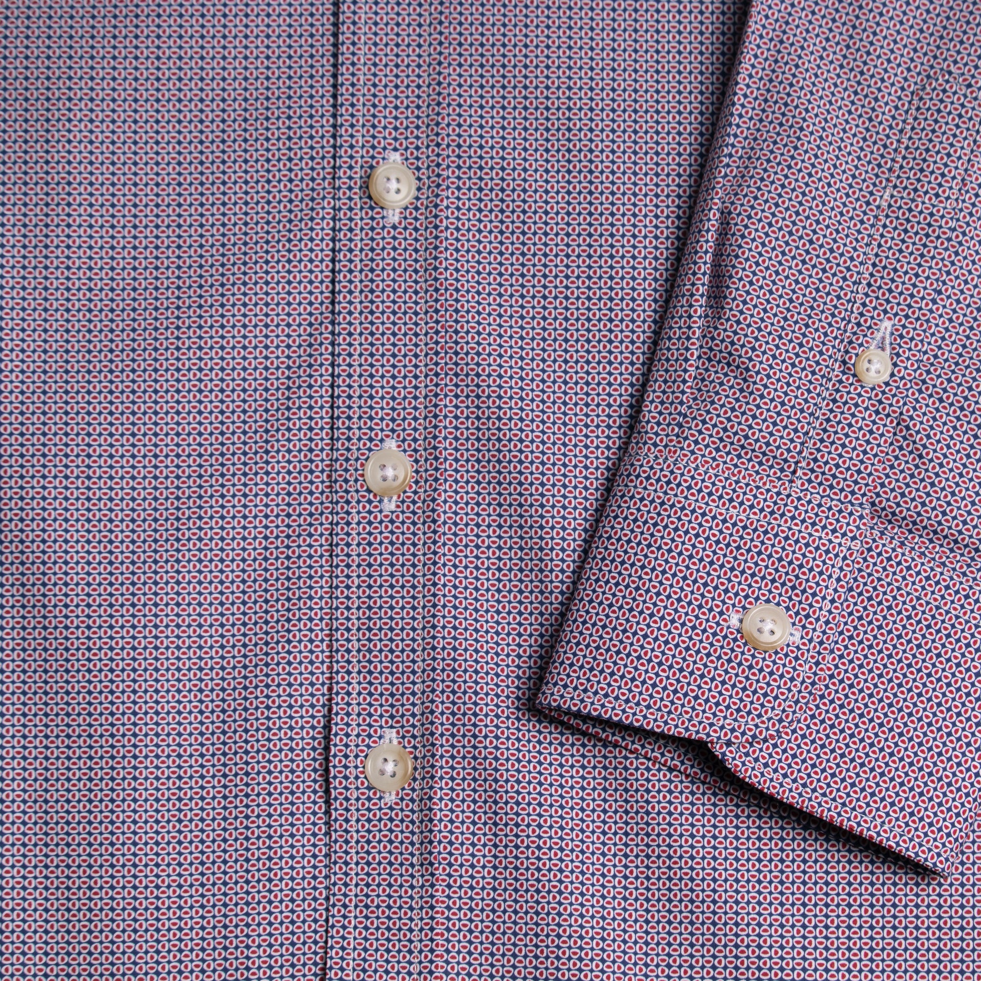 Close-up of a patterned shirt with buttons and collar. Color: Crimson Oval