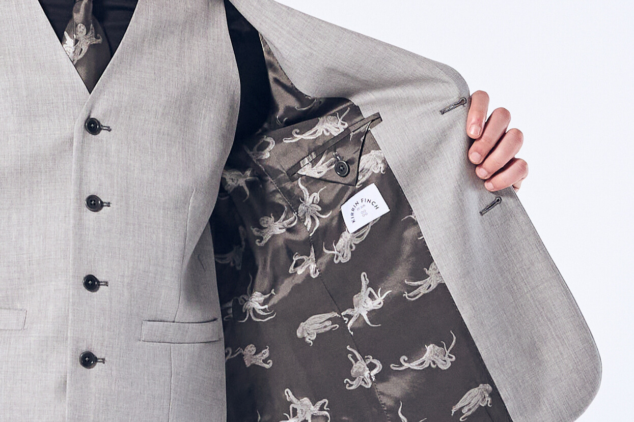 Model showcasing the interior lining of the Sky Gray Georgie blazer.  Color: Sky Gray