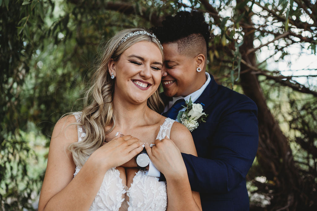 Newly weds embracing with trees in the background