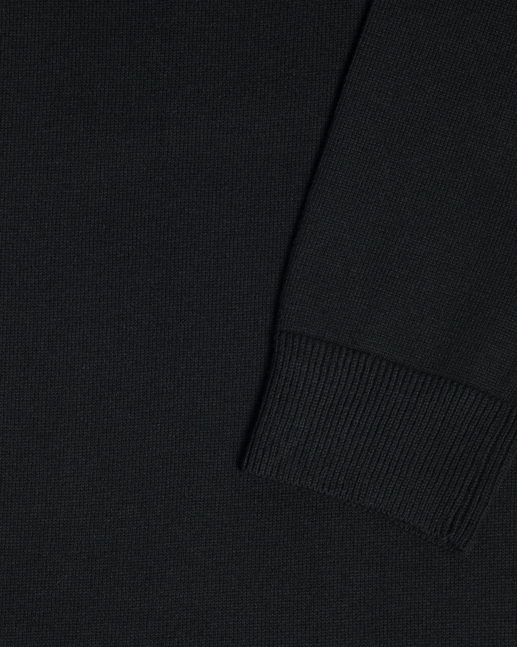 Close-up of a black garment, showing the texture of the fabric and a folded cuff detail. Color: Gray Tipped