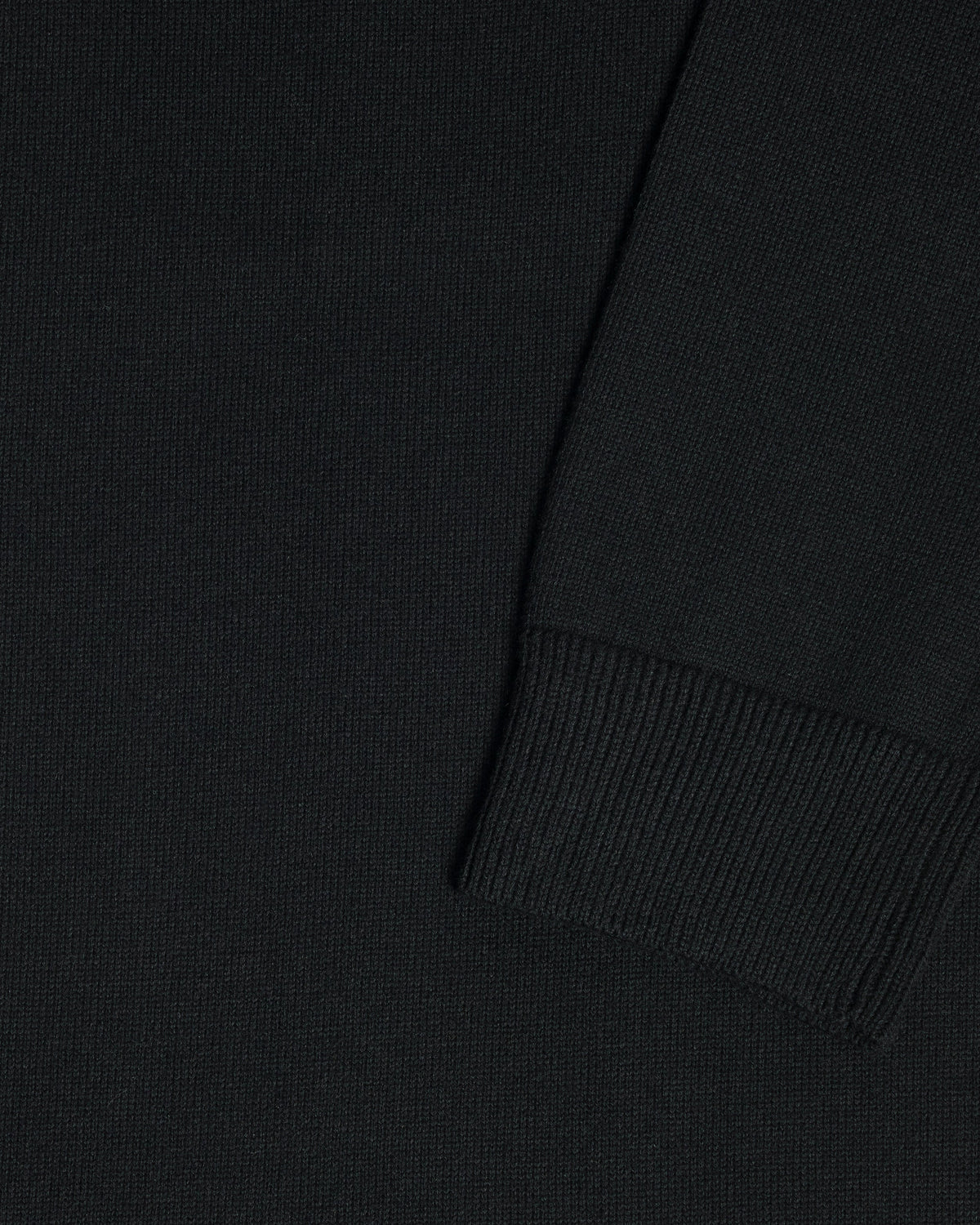 Close-up of a black garment, showing the texture of the fabric and a folded cuff detail. Color: Gray Tipped