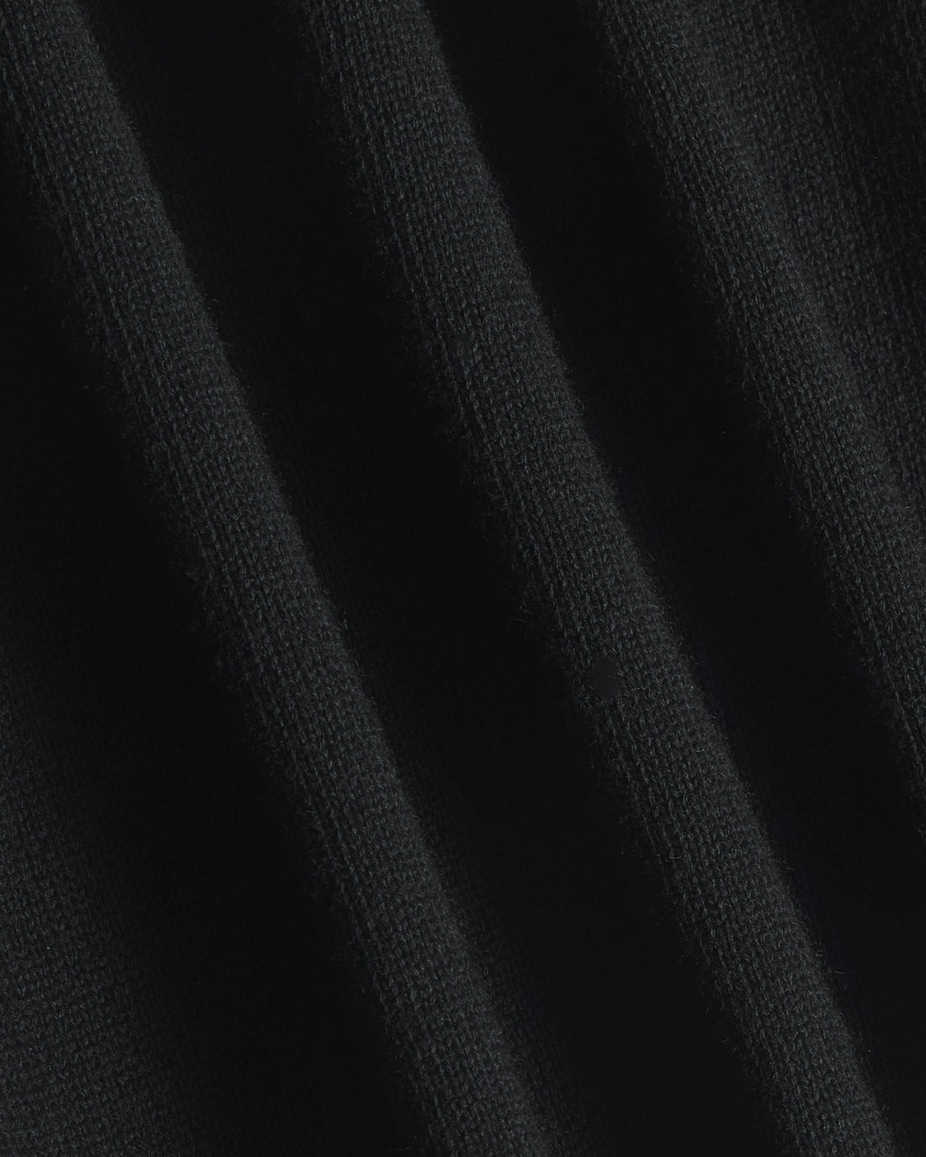 Close-up of a black ribbed knit fabric texture with soft vertical folds. Color: Gray Tipped
