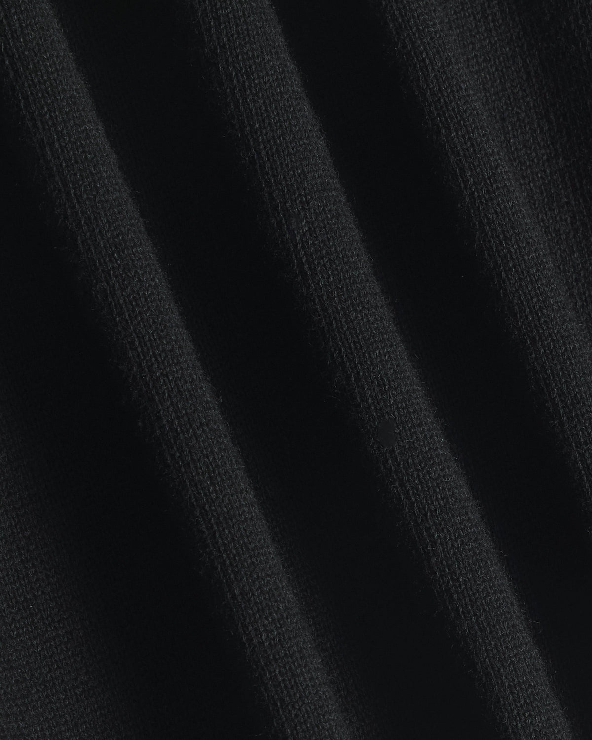 Close-up of a black ribbed knit fabric texture with soft vertical folds. Color: Gray Tipped