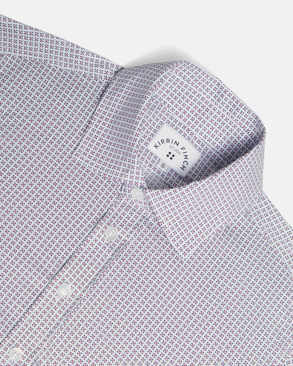 Close-up of a collared dress shirt with a small repeating geometric pattern in white, purple, and red, shown on a light gray background. Color: Navy Rosette