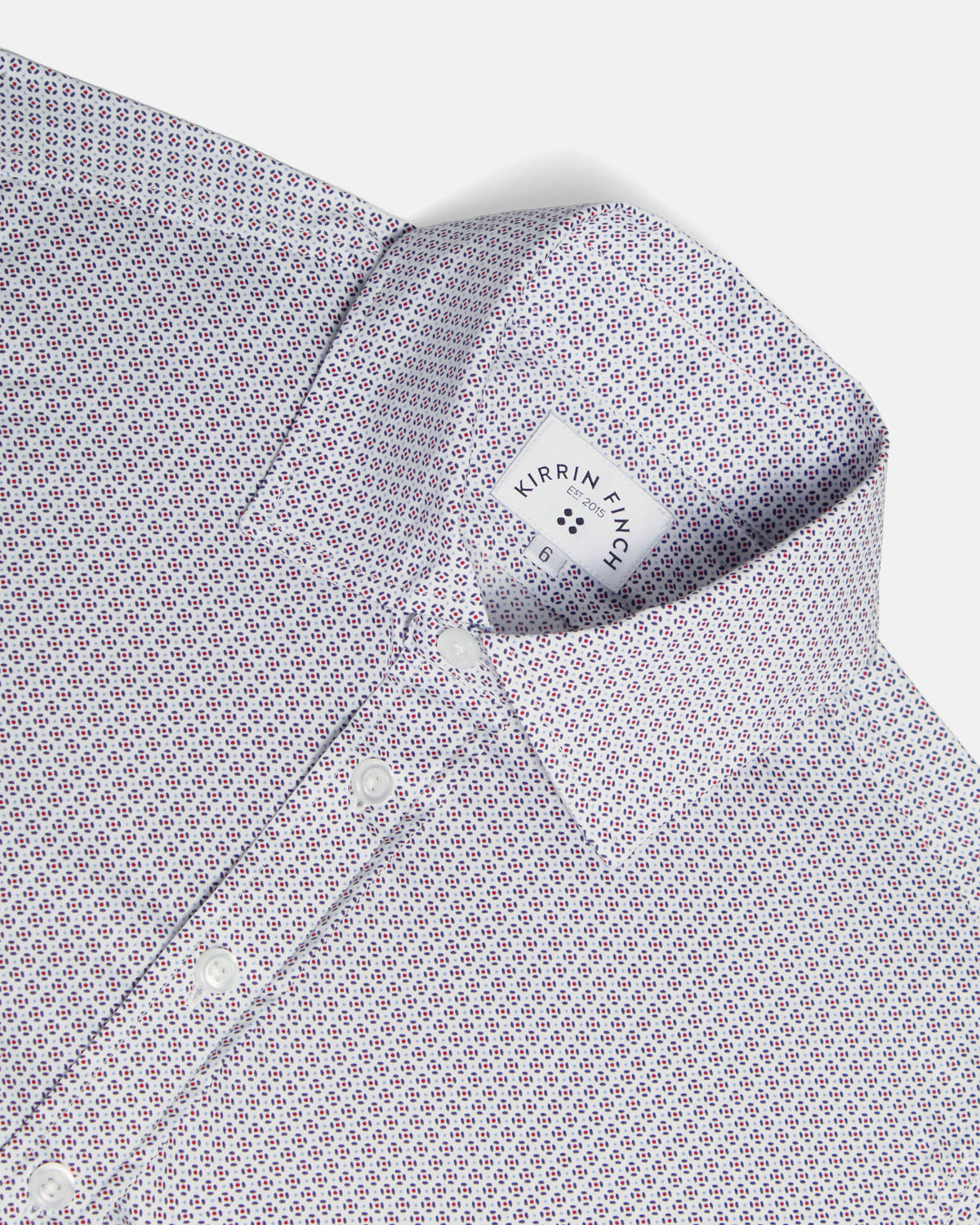 Close-up of a collared dress shirt with a small repeating geometric pattern in white, purple, and red, shown on a light gray background. Color: Navy Rosette