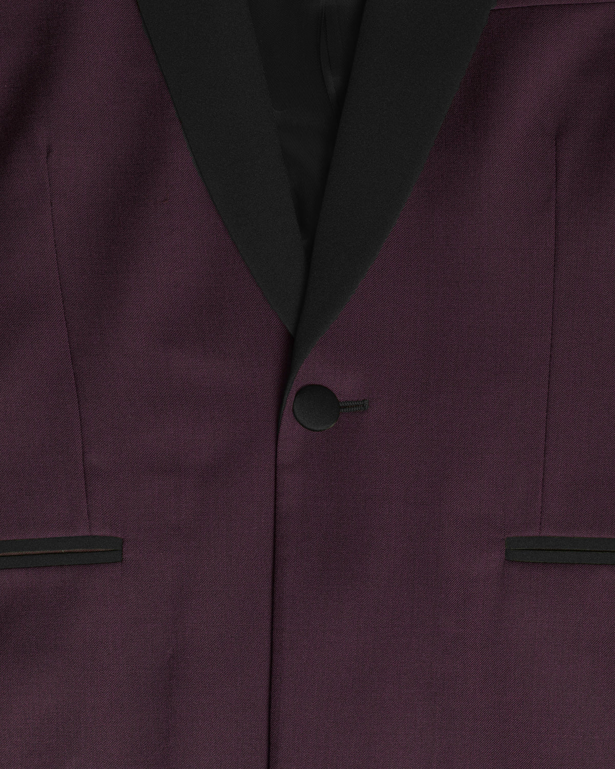 Close-up of a dark plum purple suit jacket with black satin shawl collar, a single black button, and matching black trim on the pocket flaps. Color: Deep Oxblood
