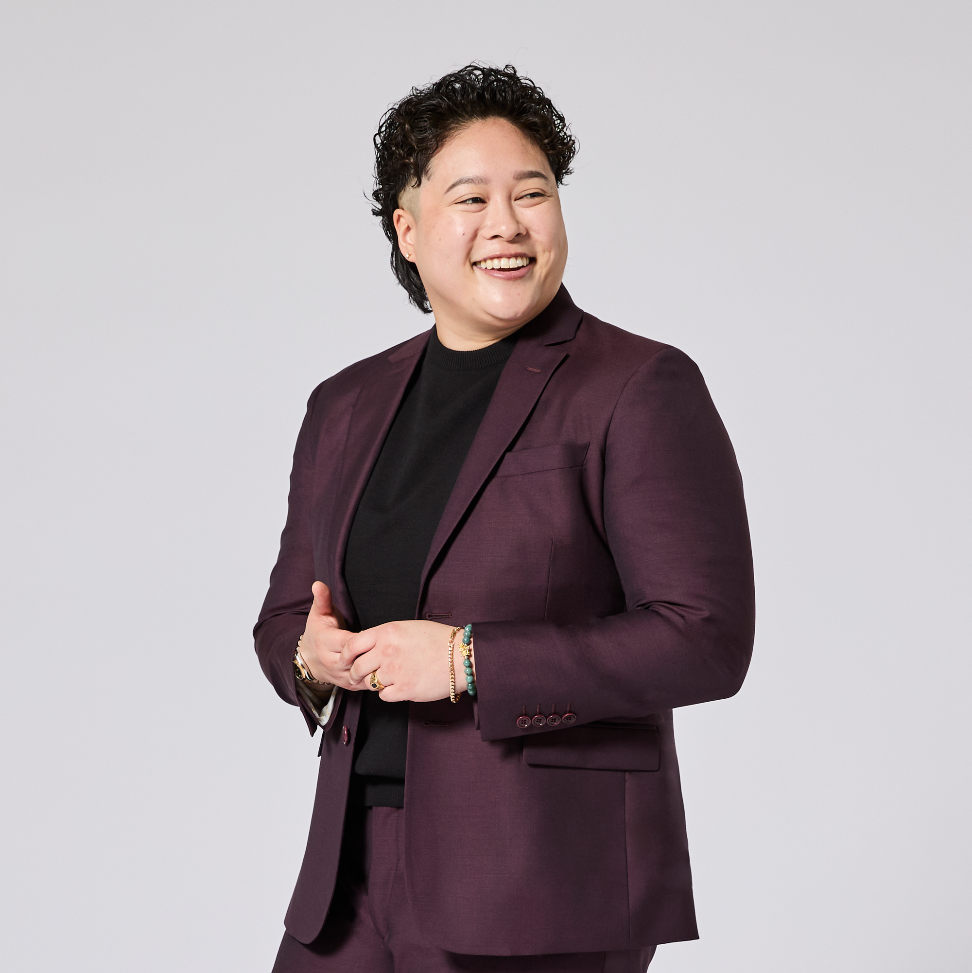 Person wearing a maroon / oxblood suit on a plain background. Color: Deep Oxblood