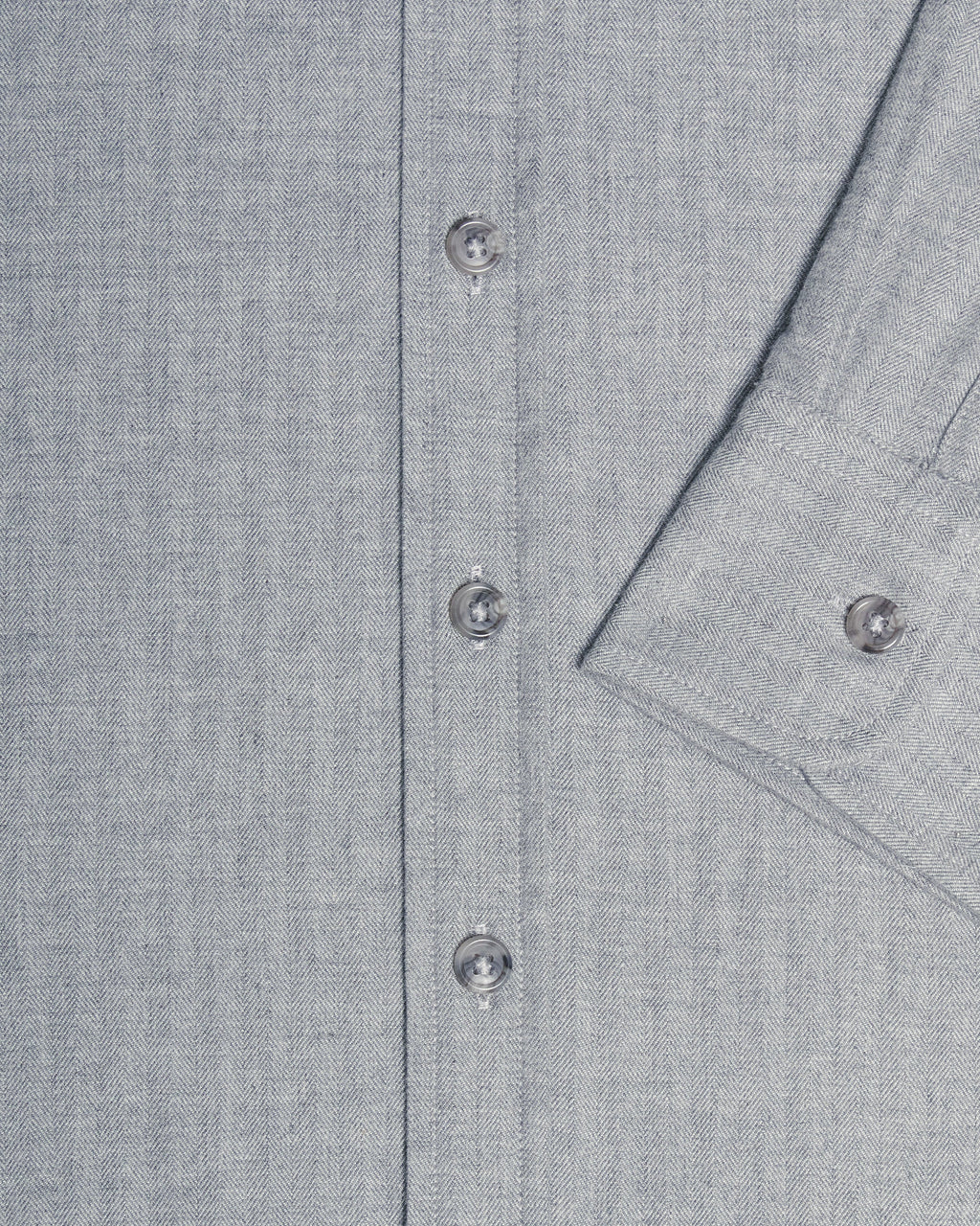 Close-up of a light gray textured button-down shirt showing the button placket and a folded cuff with a button. Color: Pewter Herringbone