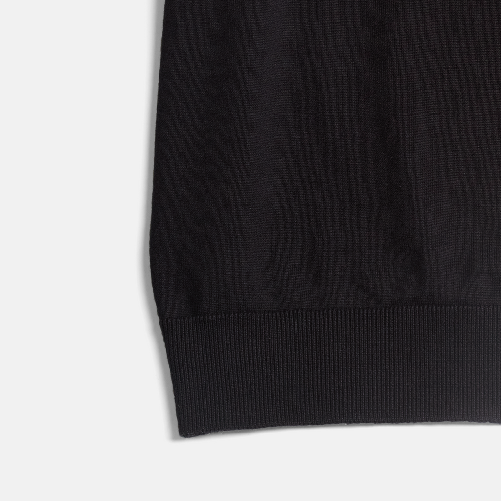 Ribbed hem of women's black crewneck shirt. Color: Black