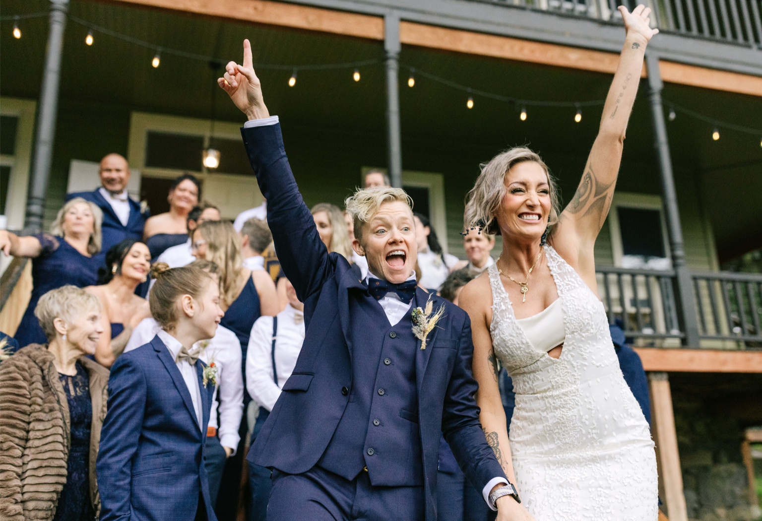 Newlyweds walking with their hand in the air.