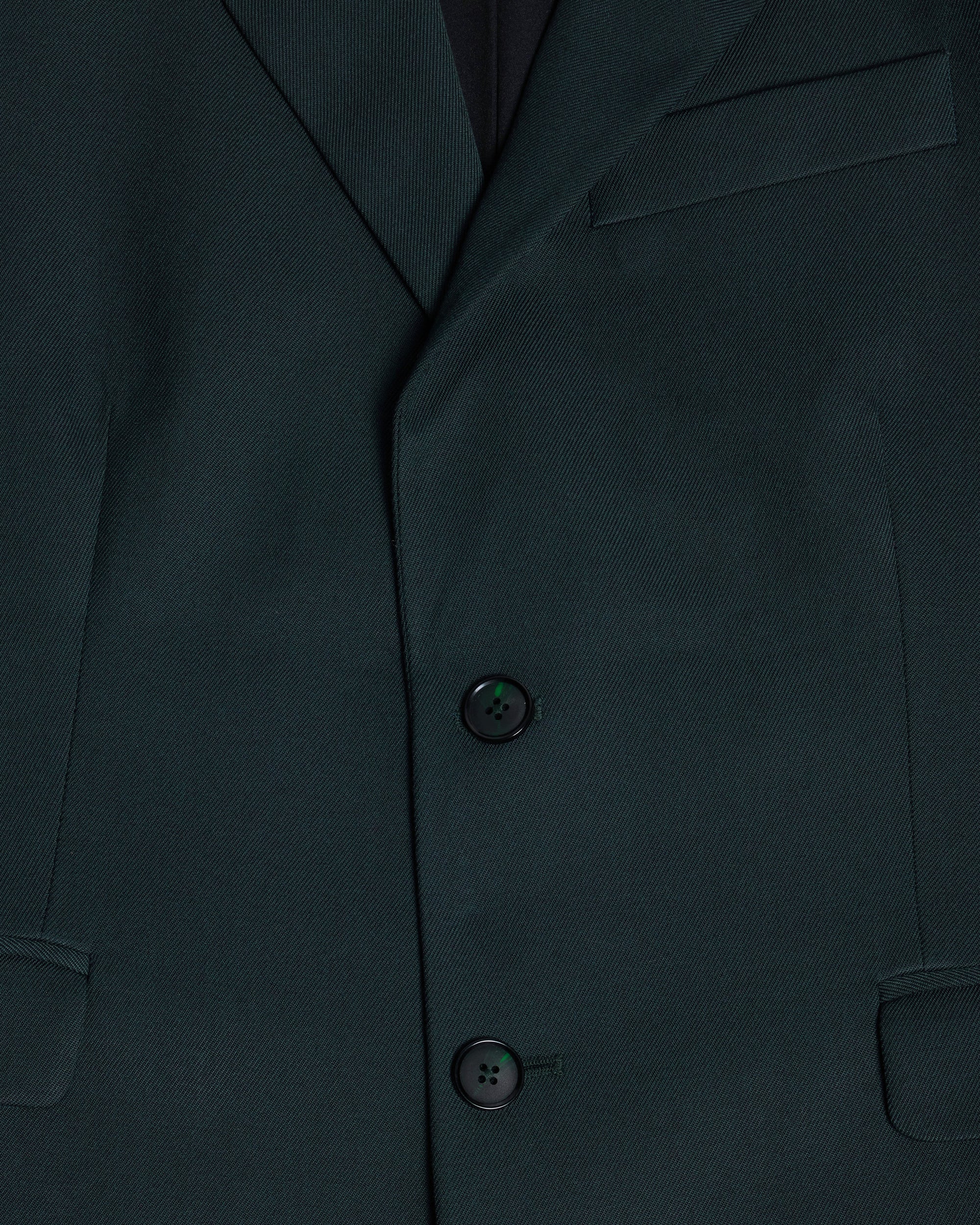 Close-up of a dark green suit jacket with buttons. Color: Phantom Green Twill