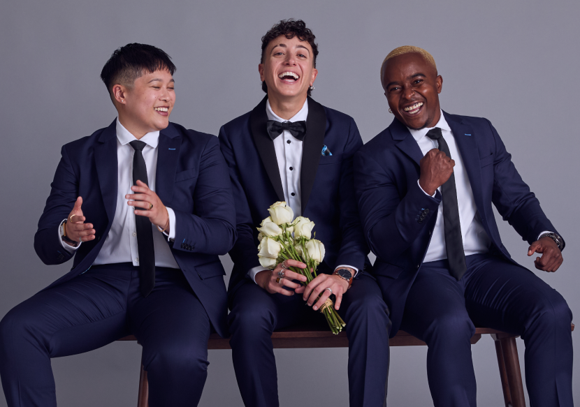 Three models on a bench wearing the navy Georgie and midnight Kirrin tuxedo suits.