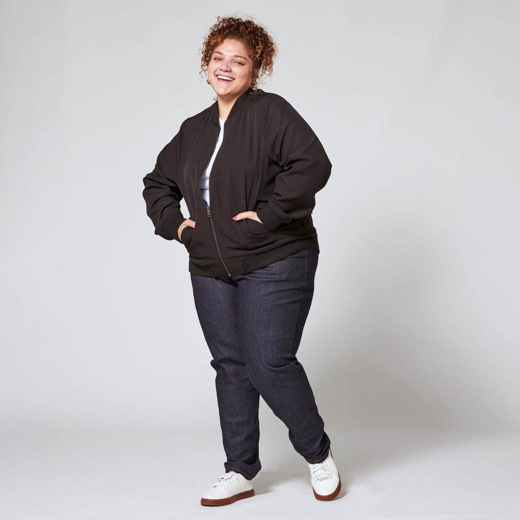 Plus size blue denim jeans on model paired with white sneakers. Color: Indigo