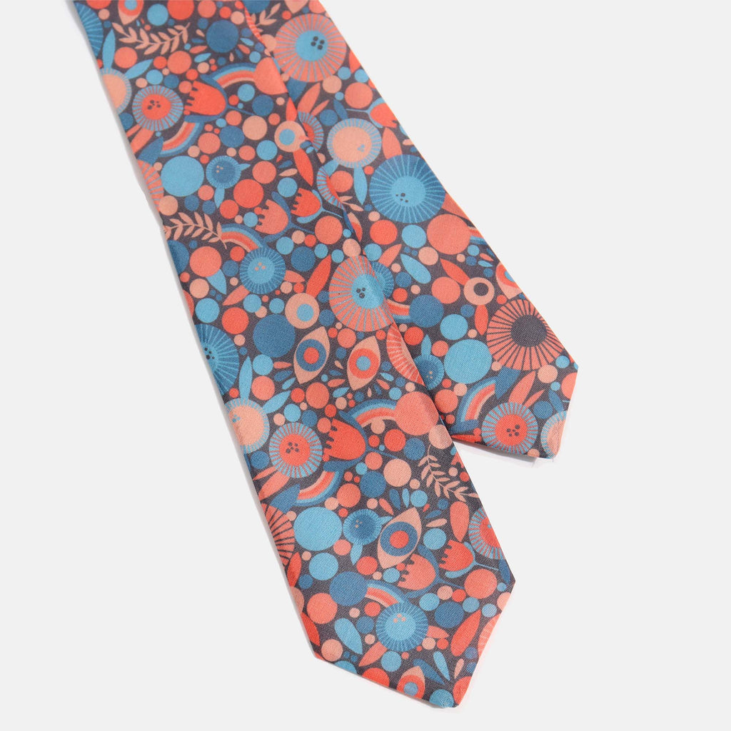 Black, blue and orange tie laid out on white background. Color: Lisa C Floral