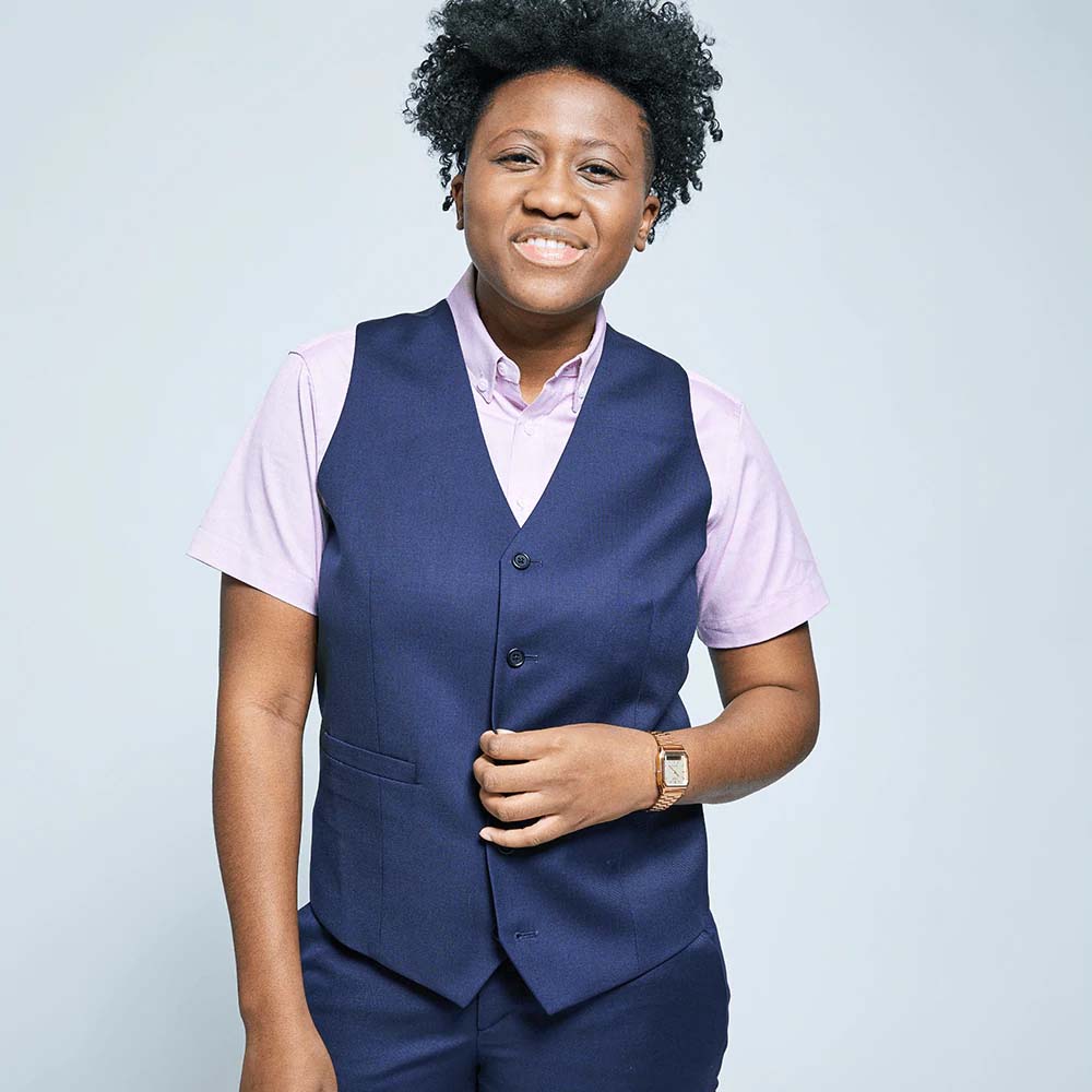 Smiling person modeling Georgie vest in navy blue on neutral background. Color: Navy