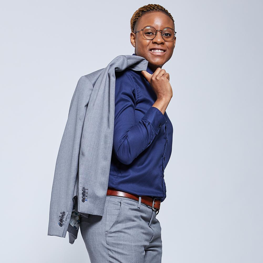 Model wearing navy Easy-care dress shirt with a gray blazer slung over shoulder. Color: Navy