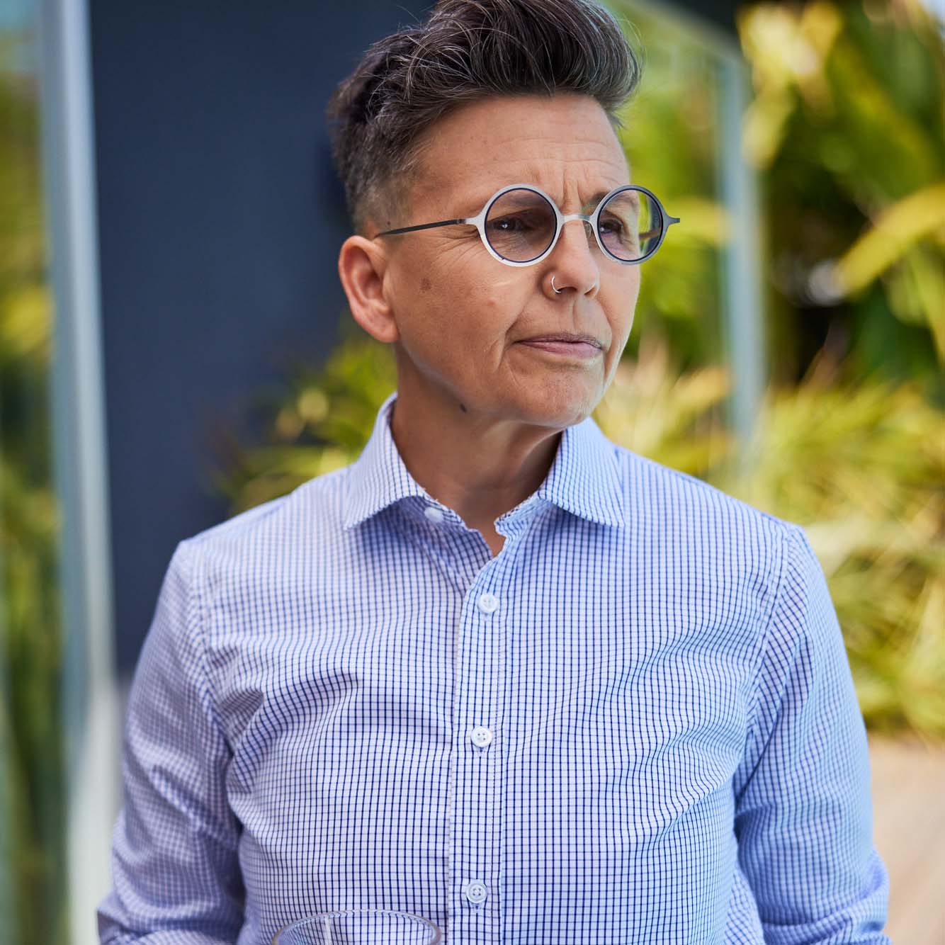 Model wearing Navy and white grid shirt with white round glasses staring sternly off into the distance. Color: Navy Grid